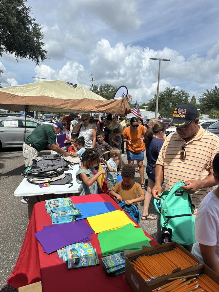 Children receiving school supplies at community event